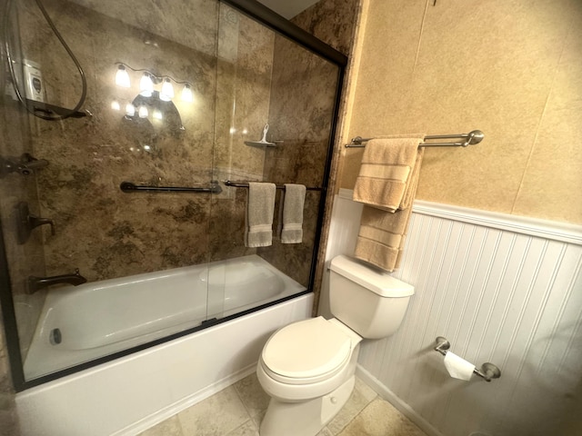 bathroom with shower / bath combination with glass door, tile patterned flooring, and toilet