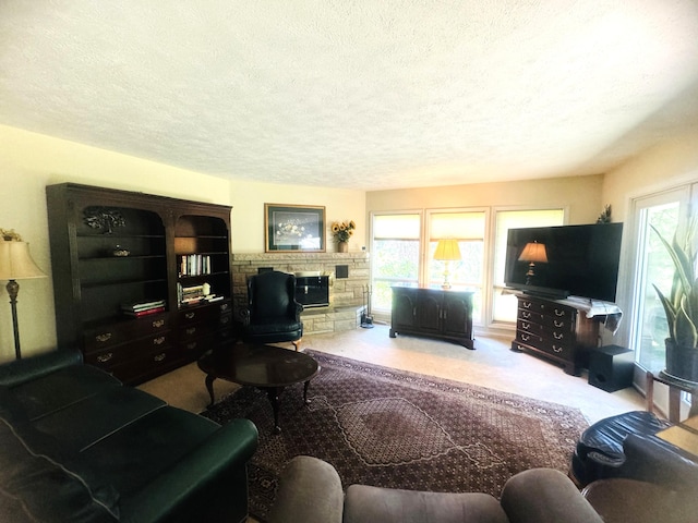 carpeted living room with a stone fireplace, a healthy amount of sunlight, and a textured ceiling