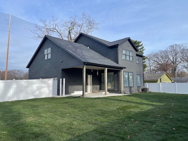 rear view of house featuring a yard, a patio area, and central AC