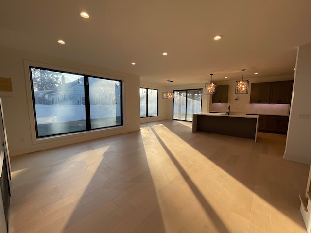 unfurnished living room featuring a chandelier