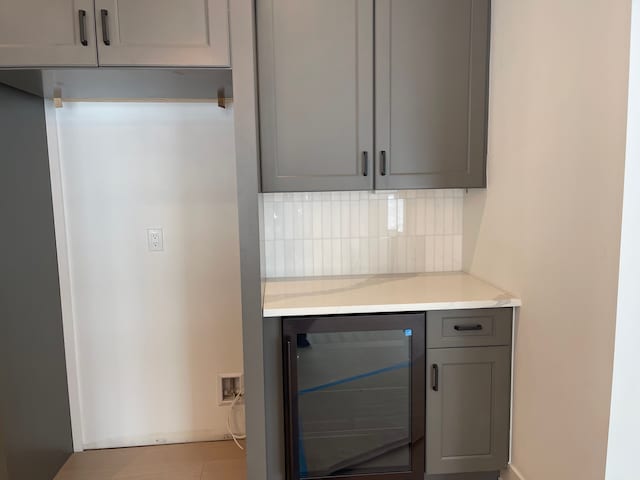 kitchen featuring gray cabinetry, backsplash, and beverage cooler