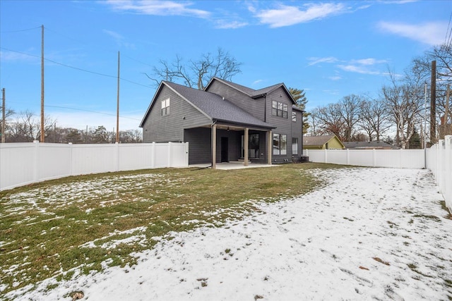 snow covered property featuring a yard and a patio