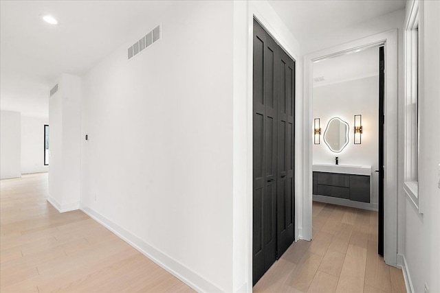 hallway with light hardwood / wood-style floors