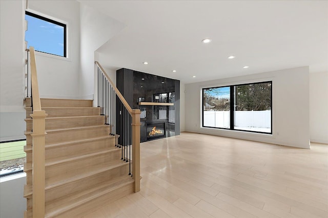 stairway with a fireplace and wood-type flooring