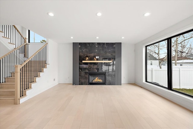 unfurnished living room featuring a wealth of natural light, a fireplace, and light hardwood / wood-style flooring