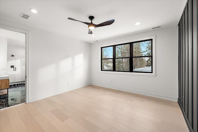 unfurnished bedroom featuring ensuite bath, light hardwood / wood-style flooring, and ceiling fan