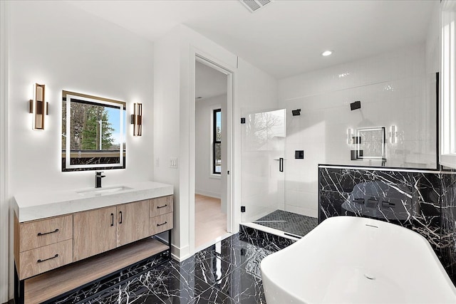 bathroom with vanity and independent shower and bath