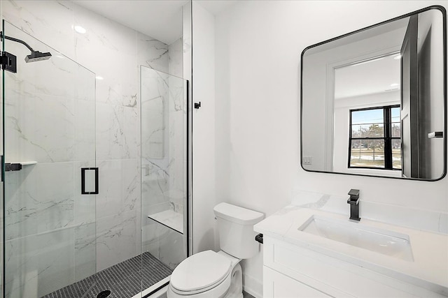 bathroom featuring vanity, toilet, and a shower with door