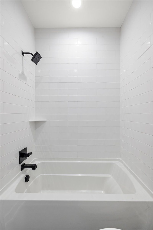 bathroom with tiled shower / bath and toilet