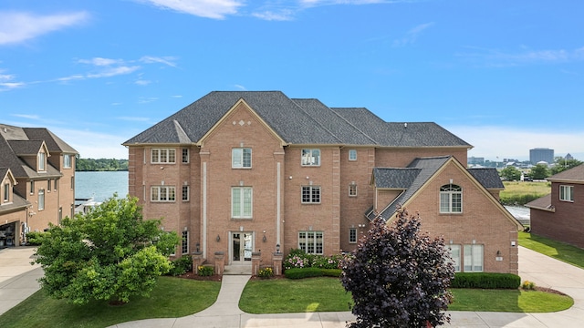 view of front facade featuring a water view and a front lawn