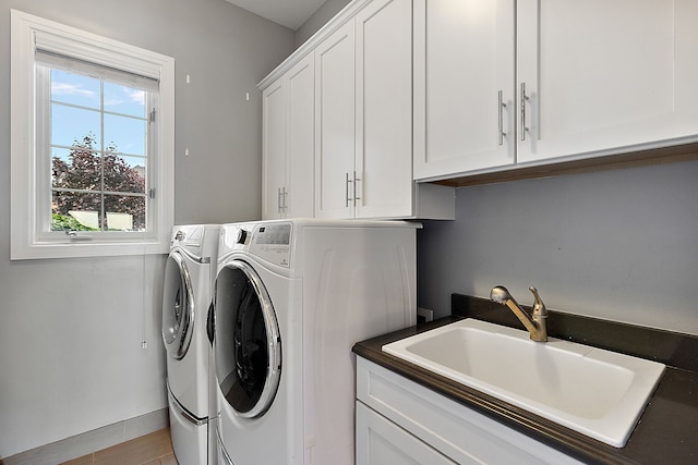 laundry area featuring cabinets, washing machine and dryer, and sink