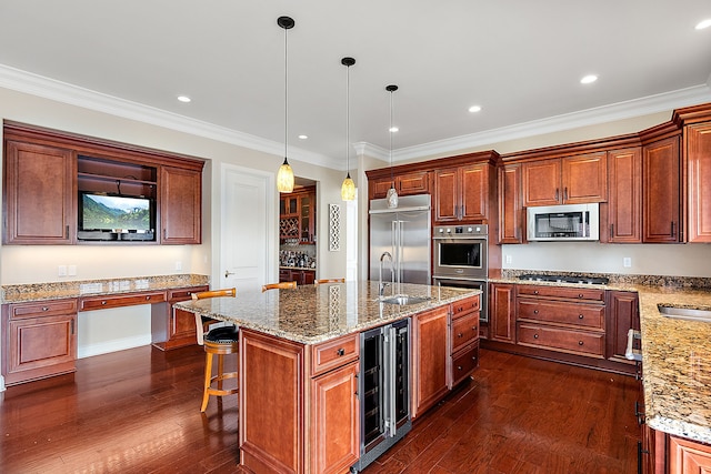 kitchen featuring dark wood-type flooring, hanging light fixtures, beverage cooler, a kitchen island with sink, and appliances with stainless steel finishes