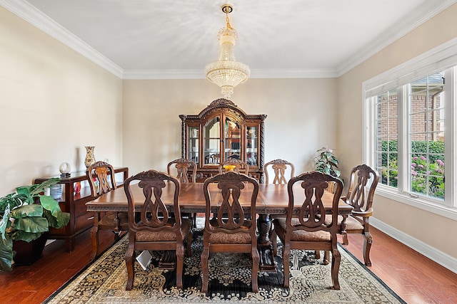 dining area with ornamental molding, wood-type flooring, and an inviting chandelier