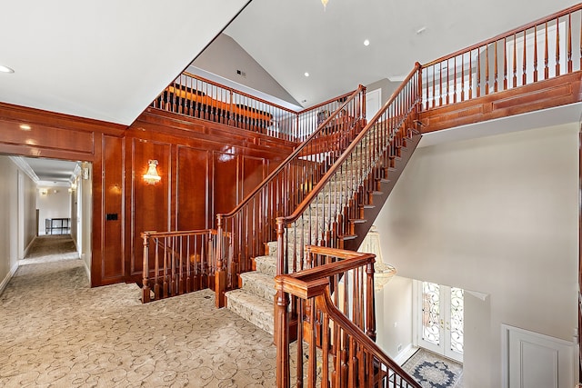 stairway featuring carpet floors and high vaulted ceiling