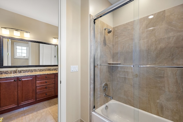 bathroom featuring tile patterned flooring, vanity, and bath / shower combo with glass door