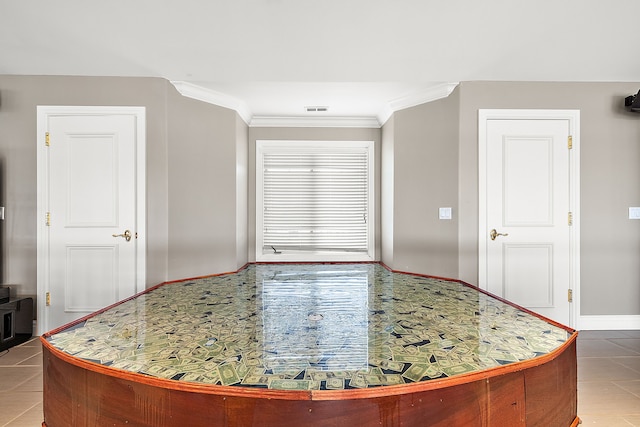 interior space with tile patterned floors and ornamental molding