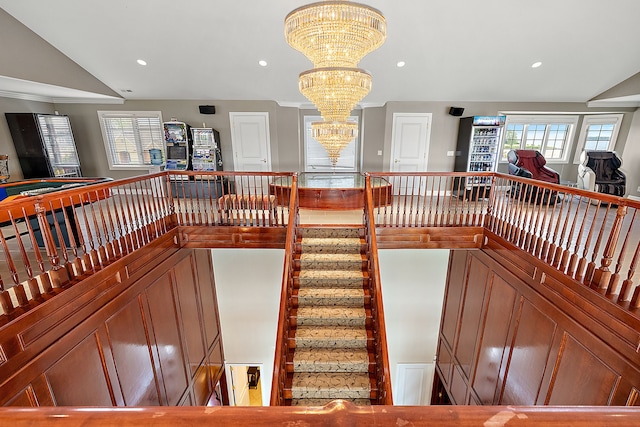 stairway with lofted ceiling and a notable chandelier