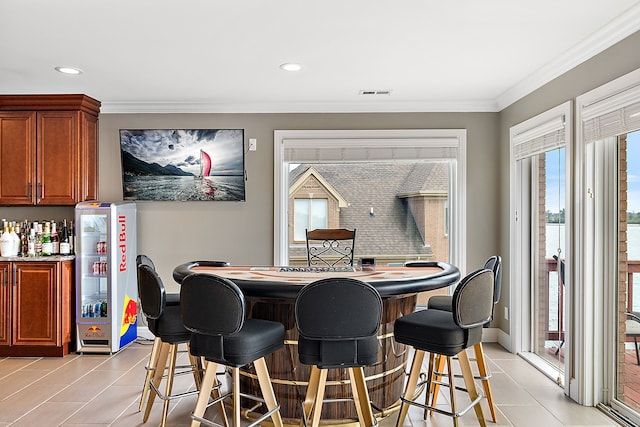 dining area with crown molding and indoor bar