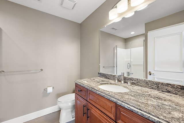 bathroom featuring tile patterned floors, vanity, toilet, and a shower with shower door