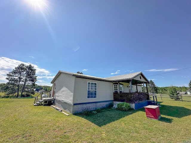 view of home's exterior with covered porch and a yard