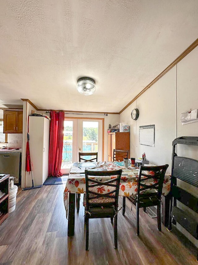 dining area featuring a textured ceiling, dark hardwood / wood-style flooring, french doors, and crown molding