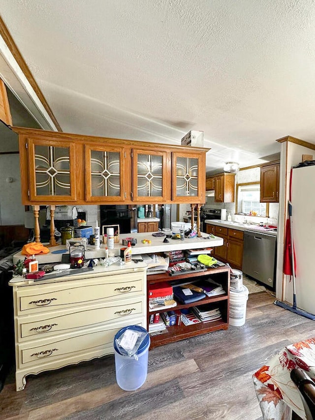 kitchen with hardwood / wood-style flooring, dishwasher, a textured ceiling, and vaulted ceiling