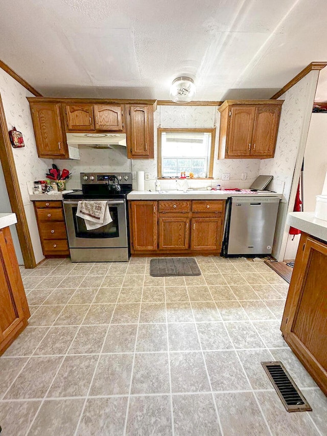 kitchen with light tile patterned floors, stainless steel appliances, and ornamental molding