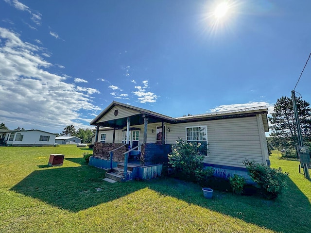 view of front of house with covered porch and a front yard