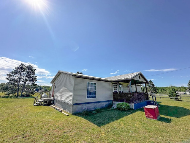 view of side of home with a yard and a porch