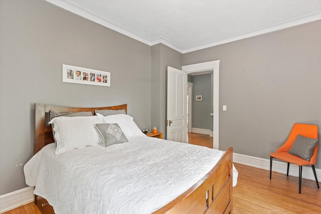 bedroom featuring light wood-type flooring and crown molding