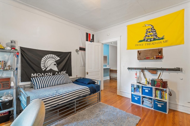 bedroom featuring hardwood / wood-style floors and crown molding