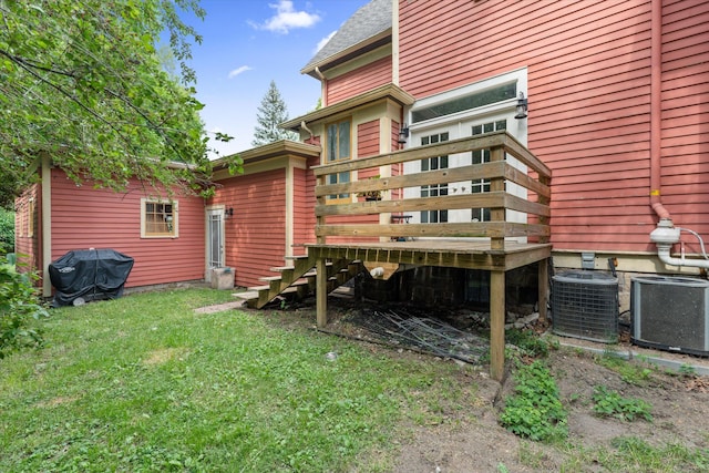 back of house featuring cooling unit, a yard, and a wooden deck