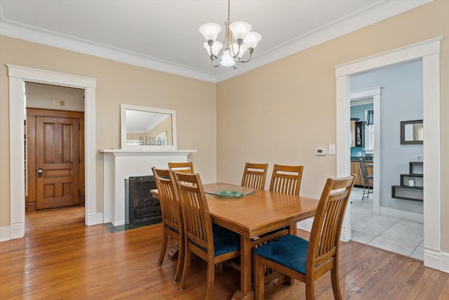 dining area featuring a chandelier, ornamental molding, and light wood-type flooring