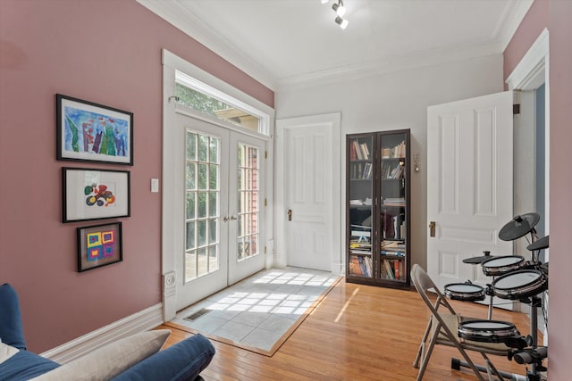 doorway to outside featuring french doors, wood-type flooring, and ornamental molding