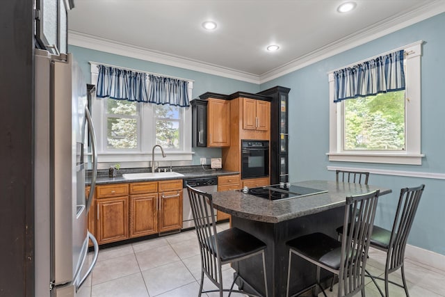 kitchen featuring black appliances, a breakfast bar, plenty of natural light, and sink