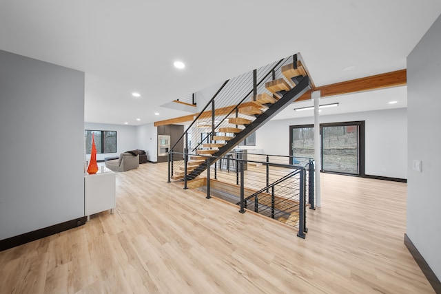 stairs featuring beam ceiling and hardwood / wood-style floors