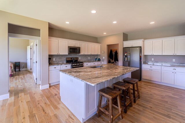 829 N Van Dyke Rd, Imlay City, MI 48444 - kitchen with stainless steel appliances, a sink, light wood finished floors, white cabinetry, and recessed lighting