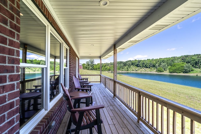 wooden deck featuring a lawn and a water view