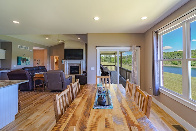 dining room featuring ceiling fan, light hardwood / wood-style floors, and vaulted ceiling