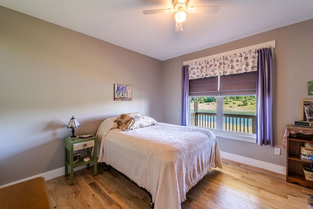 829 N Van Dyke Rd, Imlay City, MI 48444 - bedroom with baseboards, wood finished floors, ceiling fan, and a water view