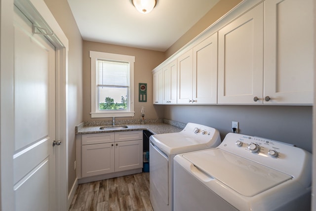 laundry area with washing machine and dryer, dark hardwood / wood-style flooring, cabinets, and sink