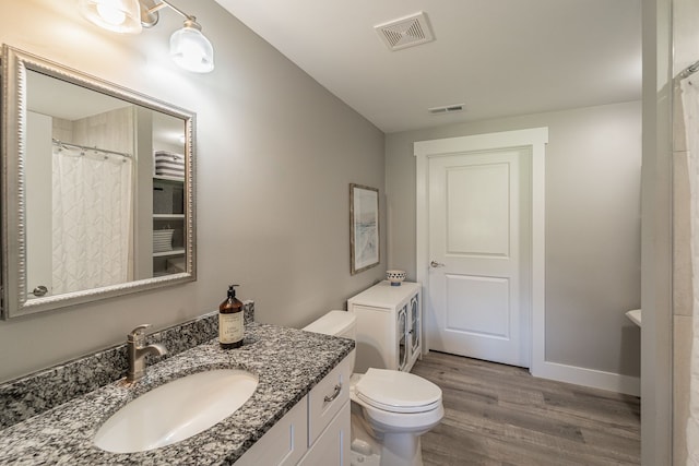 bathroom featuring hardwood / wood-style floors, vanity, and toilet