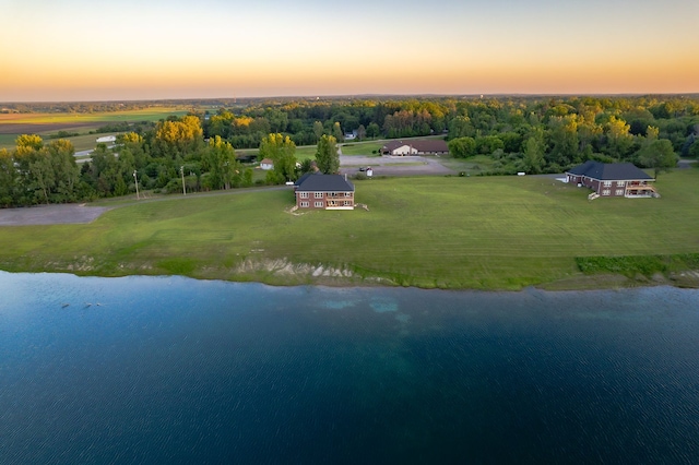 aerial view at dusk featuring a water view