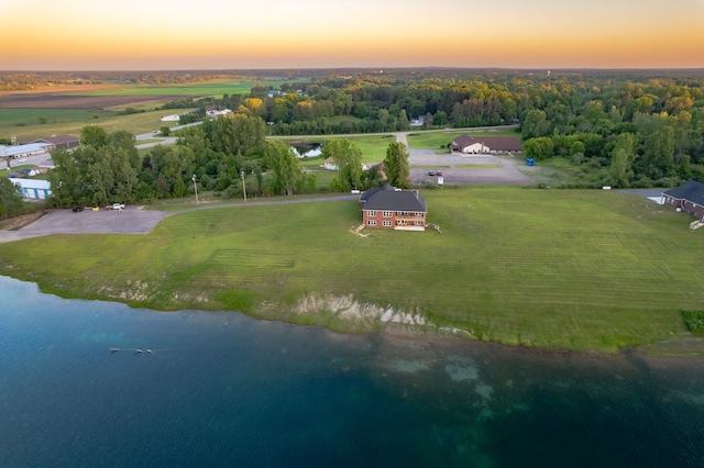 aerial view at dusk featuring a water view