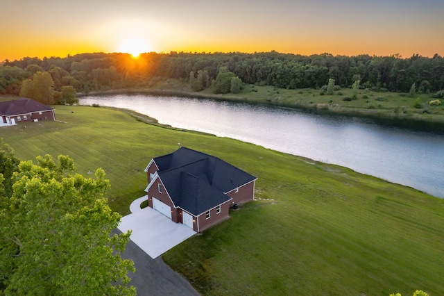 aerial view at dusk featuring a water view