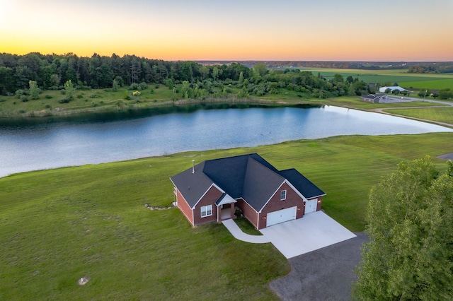 aerial view at dusk featuring a water view