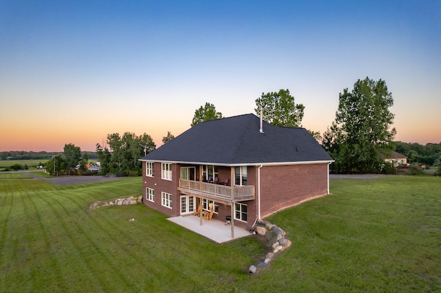 829 N Van Dyke Rd, Imlay City, MI 48444 - back of property at dusk with a patio, brick siding, a yard, and a deck