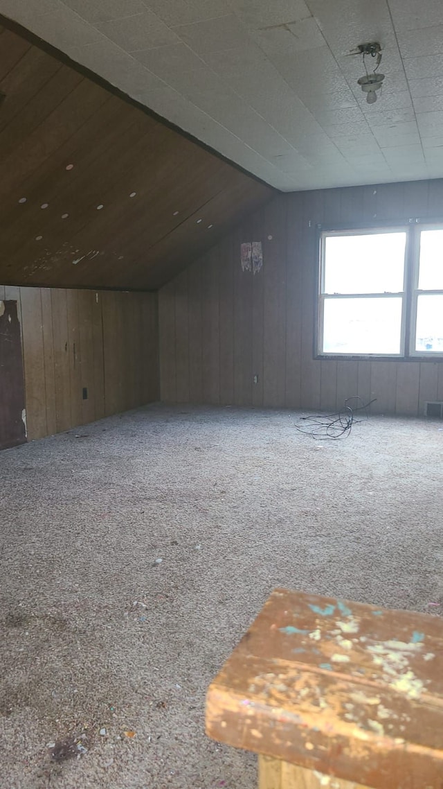 carpeted spare room with lofted ceiling