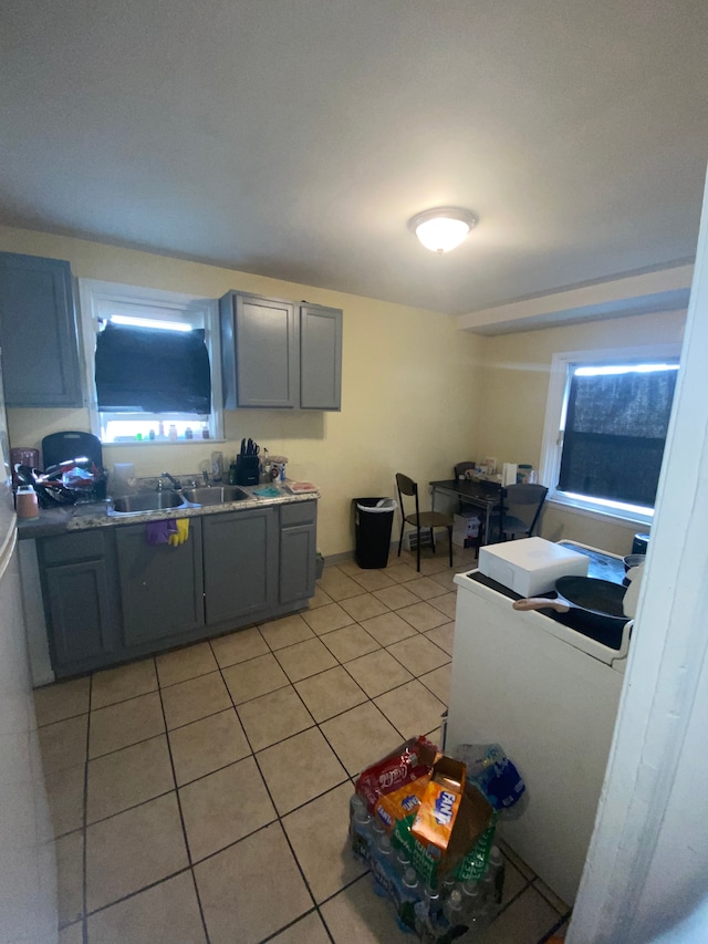 kitchen featuring light tile patterned floors, gray cabinetry, and sink