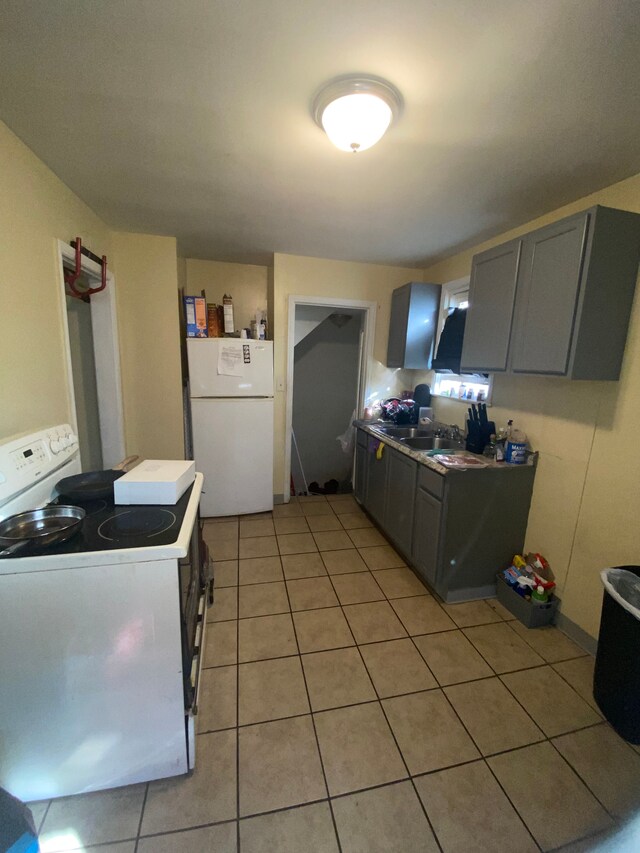 kitchen with sink, white appliances, gray cabinetry, and light tile patterned flooring